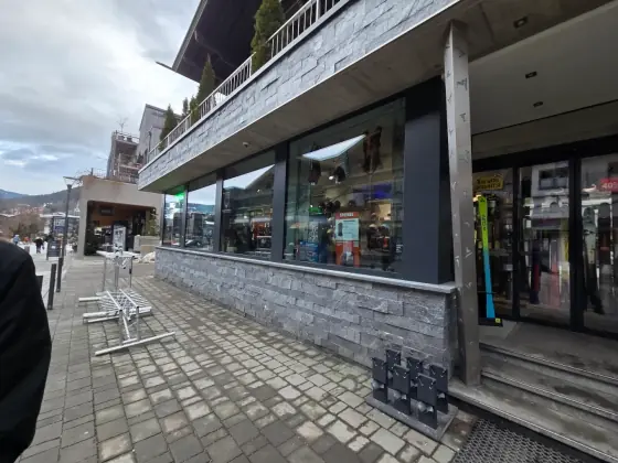 Blick die Dorfstraße entlang auf die Schaufensterfront des Shops